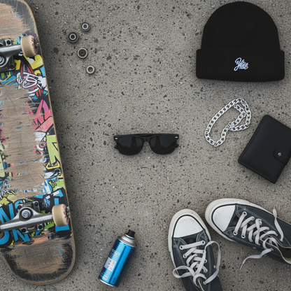 Black wayfarer sunglasses flat lay on concrete with urban accessories
